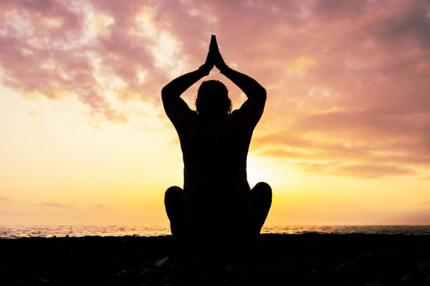 istock A man is sitting on the beach and praying 2104683717