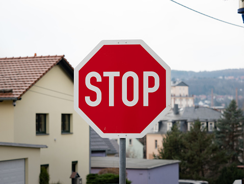 Stop road sign in Germany. Giving priority to other car drivers at the intersection of a side street. Warning signage as traffic regulation.