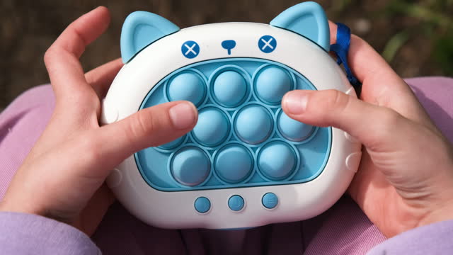 Close up video on electronic pop it fidget. Stress relieve toy pop it. Child playing Electronic Pop It. Simple board game.