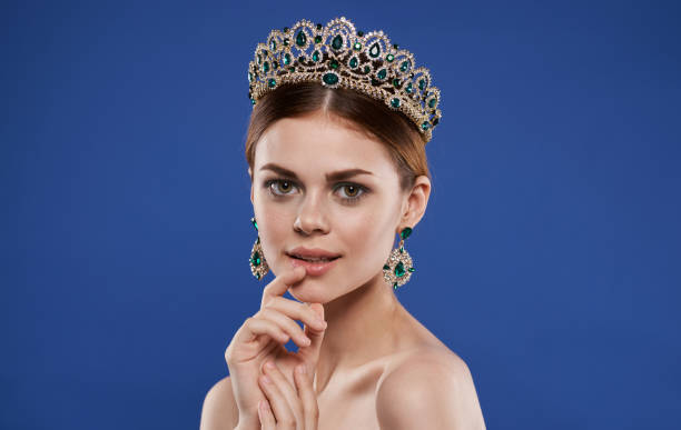 istock Charming princess with a crown on her head and earrings make-up model 2104698172