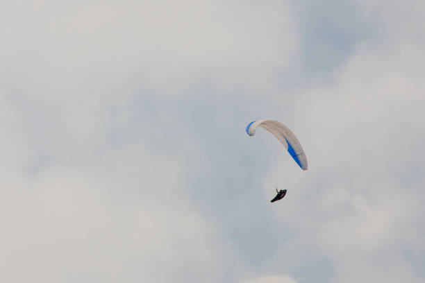A paraglider in flight in blue sky