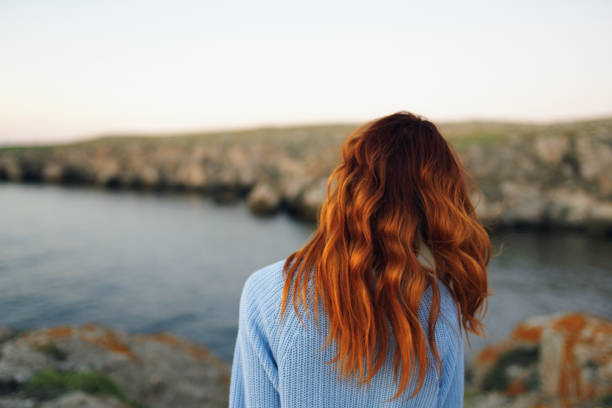 istock red-haired woman in sweater outdoors rocky mountains vacation 2104720975