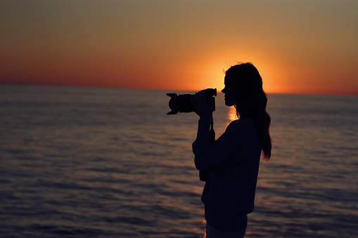 woman photographer near the sea at sunset landscape macro photography. High quality photo