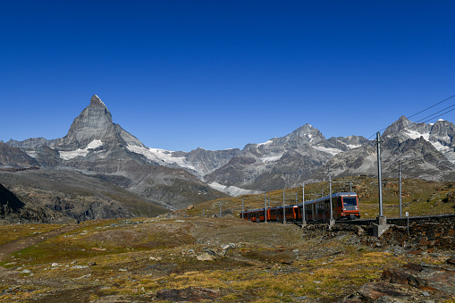 Switzerland - Aug 8, 2022: Gornergrat red tourist train with the Matterhorn peak panorama in Swiss Alps, Switzerland.