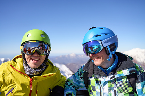 Joyful skiers in colorful helmets and goggles against a mountainous backdrop.