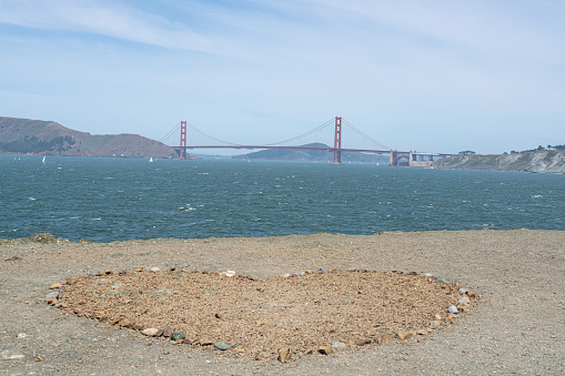 A heart shaped stone arrangement with the Golden Gate Bridge in the distance.