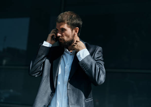 istock Business man communicates on the phone outdoors emotions executive manager lifestyle 2104832292