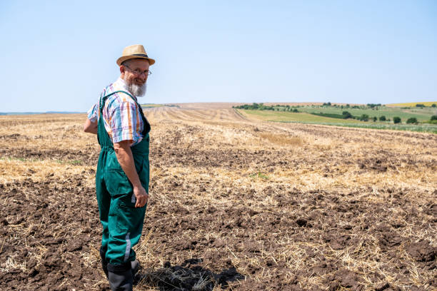 istock Cheerful white-bearded farmer on an agricultural field. 2104834393