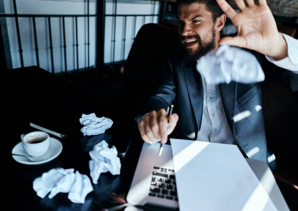 istock Business man in a cafe sitting at the table documents laptop crumpled paper executive lifestyle emotions 2104844529