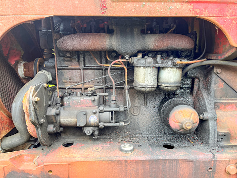 Old orange tractor engine block close up