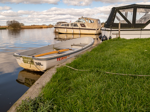 Thurne, Norfolk, UK  March 16 2023. Small row boat moored on a quiet river on the Norfolk Broads