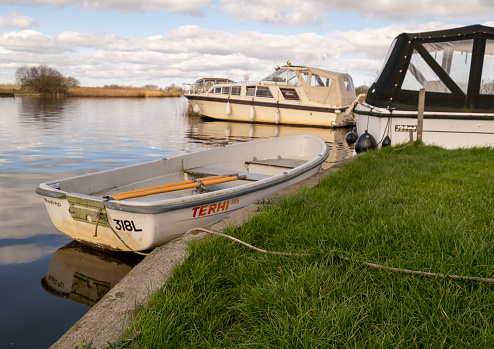 Thurne, Norfolk, UK  March 16 2023. Small row boat moored on a quiet river on the Norfolk Broads