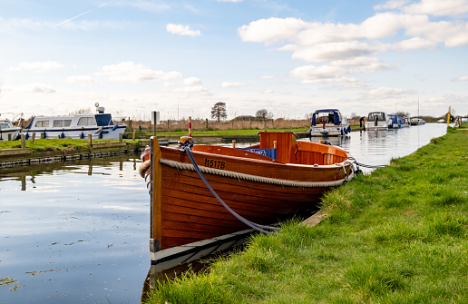Thurne, Norfolk, UK  March 16 2023. Wooden motorboat moored in Thurne Dyke in the Norfolk Broads