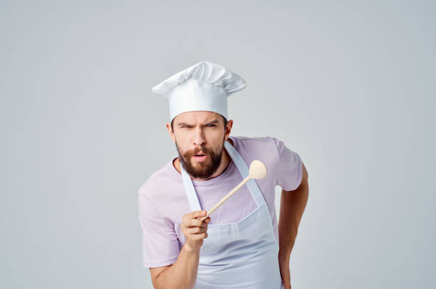 istock a man in a chef's uniform with a beard serving restaurant Professional 2104889020