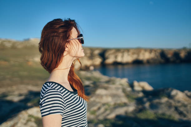 istock women blows near river look back and blue sky landscape side view 2104901653
