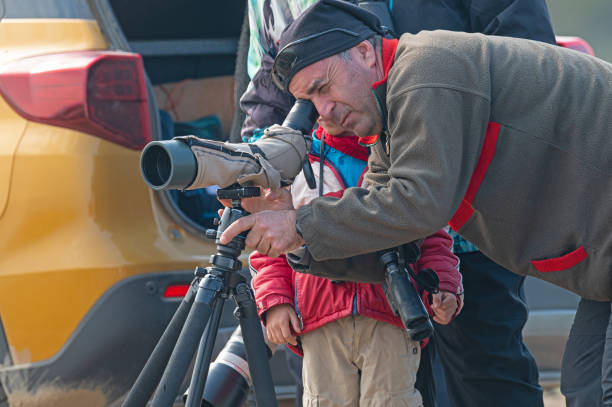Birdwatcher observing birds through a telescope.