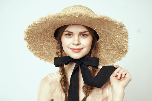 portrait of a romantic girl in a dress and a straw hat with a black ribbon emotions cropped view. High quality photo