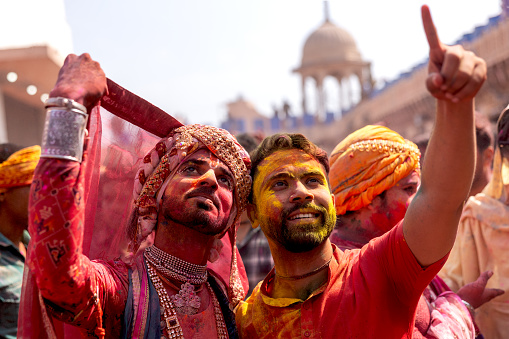 MATHURA, UTTAR PRADESH, INDIA - 2024/03/19:  Holi Celebration at Nandgaon Temple. Portrait of two male hindu devotees who are dressing like goddess radha rani during Holi Festival. These two hindu devotees are transgender. 
Holi also known as the Festival of Colours, Festival of Spring, and Festival of Love, is one of the most popular and significant festivals in Hinduism.  It celebrates the eternal and divine love of god Radha and Krishna. The day also signifies the triumph of good over evil as it commemorates the victory of god Vishnu as Narasimha Narayana over Hiranyakashipu.
Mathura, Vrindavan is the place where lord Krishna has born.

Note: This Temple is neither a privet property nor there is photography restricted. Do not need any ticket to enter this temple. This is a Hindu god lord Krishna's temple and this is public property which is maintained by temple authority.