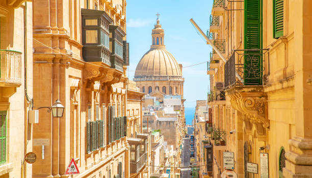 Sunny street in Valletta old town, Basilica of Our Lady of Mount Carmel on a background, Malta Sunny street in Valletta old town, Malta. Basilica of Our Lady of Mount Carmel on a background. malta stock pictures, royalty-free photos & images