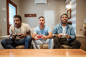 Friends Enjoying Video Games Together in Living Room
