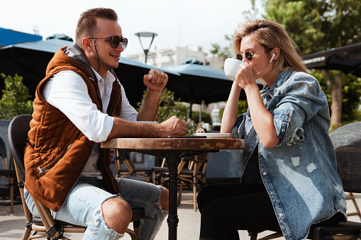 Joyful couple engaged in conversation over coffee at an outdoor cafe.