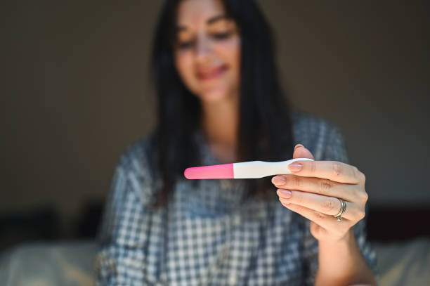 istock Woman holding positive pregnancy test. 2105031056