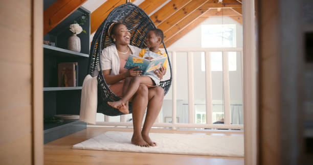 Laugh, mom and reading to kid with book for storytelling or education for learning or growth, development and bonding. Mama, girl and relax on chair with children literature for language or knowledge.
