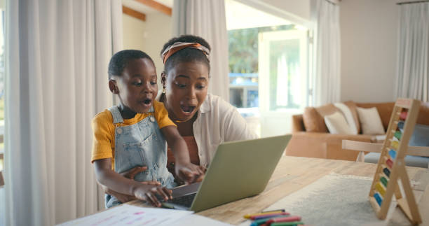istock Education, laptop and wow with black family in home for development, distance learning or study. Computer, surprise and virtual class with woman helping kid school student in dining room of apartment 2105044633