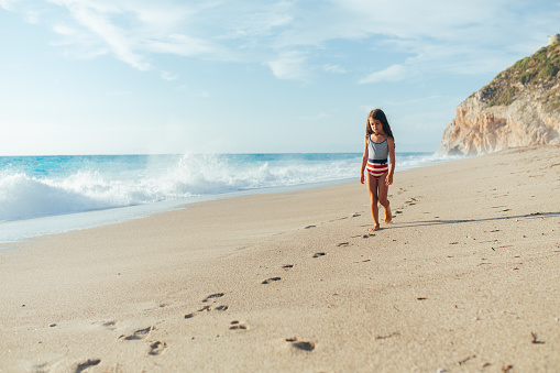 Girl walking on the coast line on the beautiful beach on the greek Lefkada island