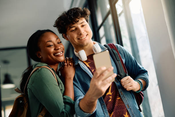istock Happy student couple taking selfie at the university. 2105096311