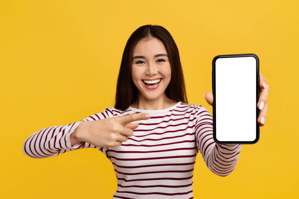 istock Positive chinese lady showing phone with white empty screen 2105098477