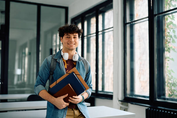 istock Happy university student in the classroom looking at camera. 2105099574