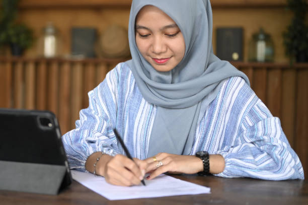 istock Close Up of hijab woman writing 2105134341