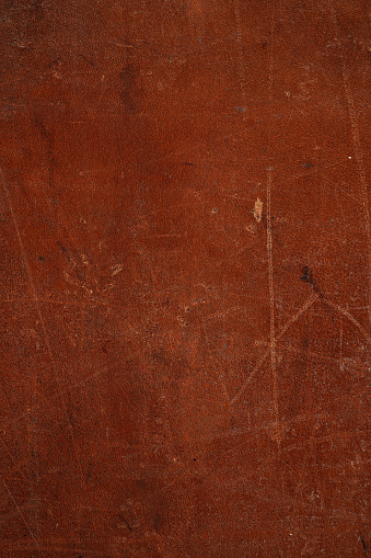 Scuffed scratched dark old leather background texture, grunge