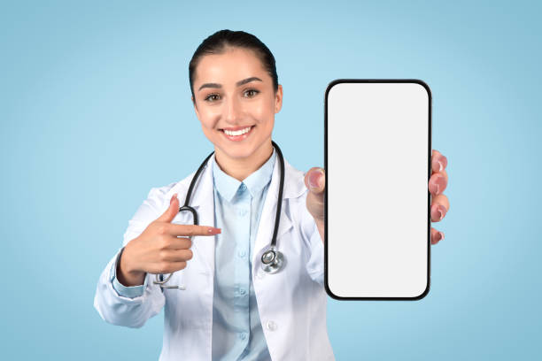 istock Happy woman doctor pointing at blank smartphone screen 2105143413