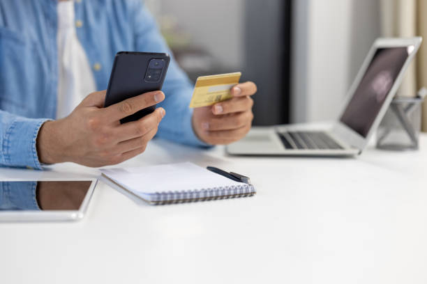 istock Man making online purchase with credit card and smartphone 2105149183