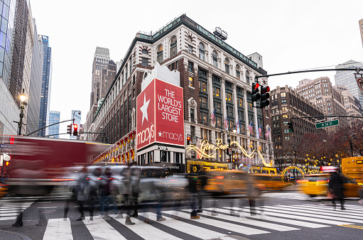 New York City, USA - December 07, 2023: Macy's Herald Square Store which is the flagship store for Macy's located on Herald Square in Manhattan, New York City. Pedestrians in crosswalk at busy midtown Manhattan shopping district of Herald Square. Image taken with a wide angle lens