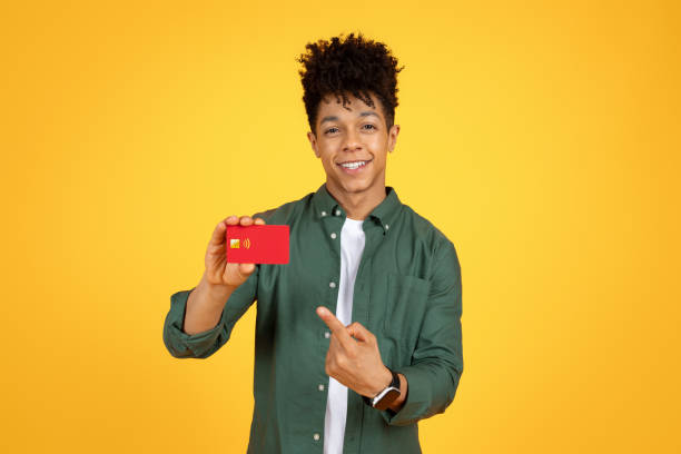 istock Cheerful young black guy showing bank card 2105198275