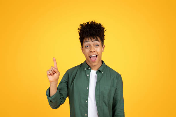 istock Excited african american guy raising finger up, yellow background 2105198281