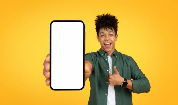istock Cheerful african american young man showing phone with blank screen 2105198285