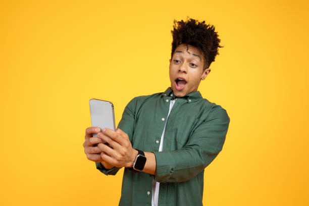 istock Amazed african american guy looking at smartphone screen 2105198286