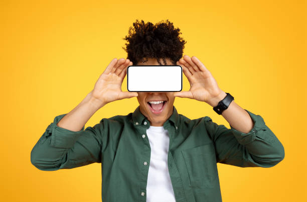 istock Black guy holding smartphone with white screen over his eyes 2105198807