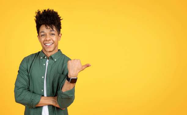 istock Cool handsome african american guy pointing at copy space 2105198819