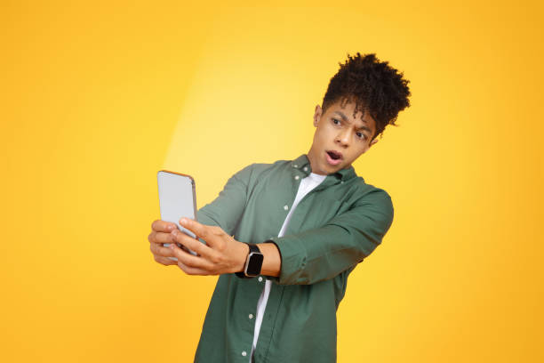 istock Shocked young black guy looking at smartphone screen 2105198823
