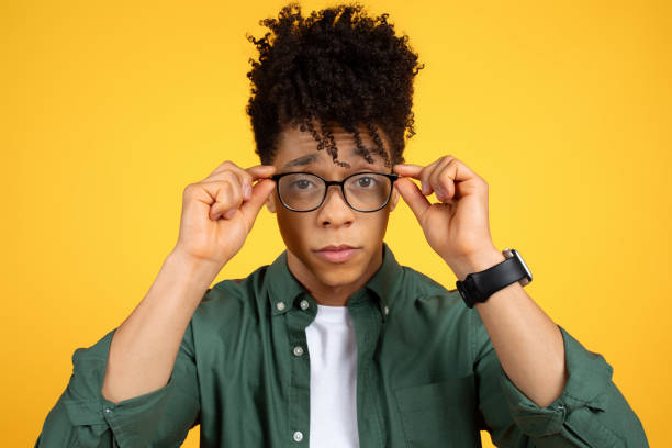 istock Black guy wearing casual clothing adjusting his eyeglasses 2105198863