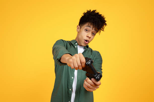 istock Happy young black guy with joystick playing video game 2105199379