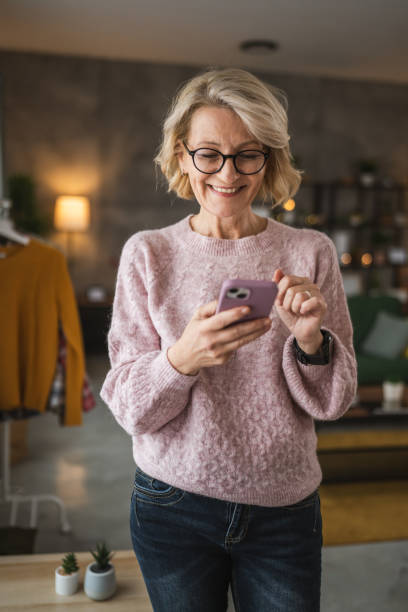 istock One woman mature caucasian female use mobile smart phone sms texting 2105199932