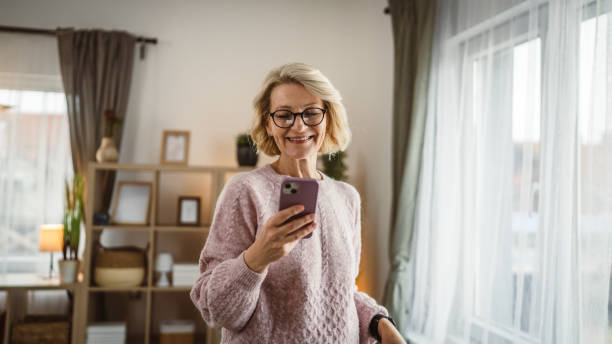 istock One woman mature caucasian female use mobile smart phone sms texting 2105200444
