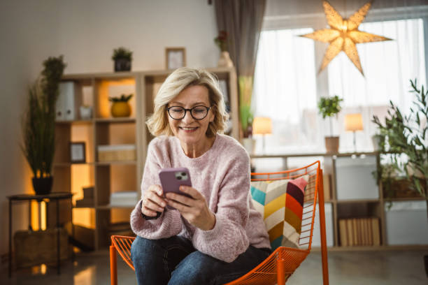 istock One woman mature caucasian female use mobile smart phone sms texting 2105200450