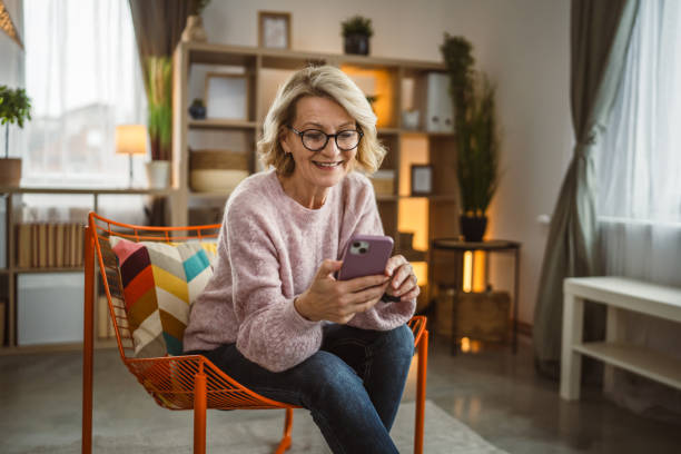 istock One woman mature caucasian female use mobile smart phone sms texting 2105200455